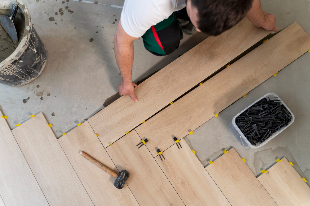 Professional worker installing wooden laminate flooring in a residential space